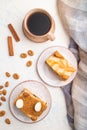 Honey cake with milk cream, caramel, almonds and a cup of coffee on a white concrete background. Top view, close up Royalty Free Stock Photo