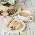 Honey cake on a white table with cup of coffe. Cake with cream flowers. Close up, copy space. Royalty Free Stock Photo