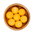 Honey Cantaloupe melon balls, freshly cut out, in a wooden bowl