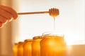 Honey dipper over bottles with honey Royalty Free Stock Photo