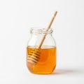 Honey dipper rests inside the jar with some honey drizzling down its Royalty Free Stock Photo