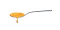 Honey drip in a spoon on white background. Royalty Free Stock Photo