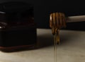 Honey dripping  on black background and Jars of honey. Royalty Free Stock Photo