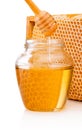 Honey dripping from dipper into glass jar on background honeycomb Royalty Free Stock Photo