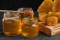 Honey dripping from dipper into jar on table Royalty Free Stock Photo