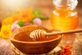 Honey dripping from honey dipper in wooden bowl.  Close-up. Healthy organic Thick honey dipping from the wooden honey spoon Royalty Free Stock Photo