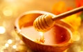 Honey dripping from honey dipper in wooden bowl.  Close-up. Healthy organic Thick honey dipping from the wooden honey spoon Royalty Free Stock Photo
