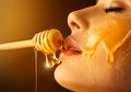 Honey dripping from honey dipper on sexy girl lips. Thick honey dipping from the wooden honey spoon. Beauty model woman Royalty Free Stock Photo