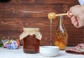 Honey dripping from honey dipper in wooden bowl. Close-up. Healthy organic Thick honey dipping from the wooden honey spoon, closeu Royalty Free Stock Photo