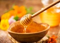 Honey dripping from honey dipper in wooden bowl.  Close-up. Healthy organic Thick honey dipping from the wooden honey spoon Royalty Free Stock Photo