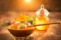 Honey dripping from honey dipper in wooden bowl. Healthy organic thick honey pouring from the wooden honey spoon Royalty Free Stock Photo