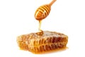 Honey dripping on honeycomb over white background Royalty Free Stock Photo