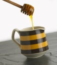 Honey dripping into pot Royalty Free Stock Photo