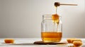 Honey dripping from a wooden honey dipper into a glass jar on a white background Royalty Free Stock Photo
