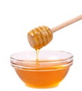 Honey dripping from a wooden dipper.