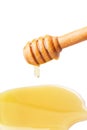 Honey dripping from a wooden honey dipper on isolate white background. Royalty Free Stock Photo