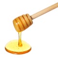 Honey dripping from wooden honey dipper isolated on white