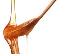 Honey dripping from a wooden honey dipper isolated on white back Royalty Free Stock Photo