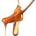 Honey dripping from a wooden honey dipper isolated on white back Royalty Free Stock Photo