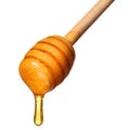 Honey dripping from wooden honey dipper isolated