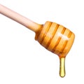 Honey dripping from wooden honey dipper isolated on white Royalty Free Stock Photo