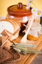 Honey, flowers and bread on table