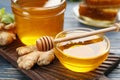 Honey and ginger on blue wooden table, closeup. Natural cold remedies Royalty Free Stock Photo