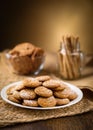 Honey ginger cookies in the foreground. Oatmeal raisin cookies and pirouette rolled wafers in the background. Jute, burlap on woo Royalty Free Stock Photo