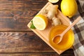 Honey, ginger, lemons and towel on wooden background