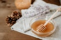 Honey in glass bowl with wooden spoon and Russian sage over wood