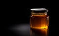 Honey glass jar on black background with copy space
