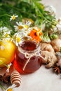 Honey in a glass jar with camomile calendula flowers, ginger root, garlic, anise - immunity tea ingredients, seasonal concept of