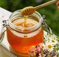 Honey in glass jar and flowers on a wooden floor Royalty Free Stock Photo