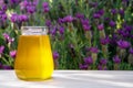 Honey in glass jar on wooden table on nature lavender background. Outdoor Royalty Free Stock Photo