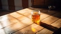 Honey glass lifestyle product shot. A full glass of beautiful honey on a wooden table. Play light and shadow