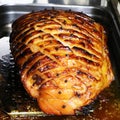 honey glazed gammon ham with traditional herbs and spicesin a roasting tray