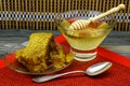 Honey with honeycomb in a glass plate on old wooden table