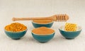 Honey, honeycomb, pollen granules and cinnamon in bowls