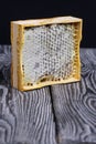 Honey in honeycombs in a wooden frame. On black pine boards. On a black background Royalty Free Stock Photo
