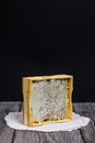 Honey in honeycombs in a wooden frame. On black pine boards. On a black background Royalty Free Stock Photo