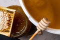 Honey in jar and big bucket, honeycomb and wooden stick