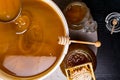 Honey in jar and big bucket, honeycomb and wooden stick, metal ladle Royalty Free Stock Photo