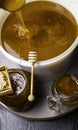 Honey in jar and big bucket, honeycomb and wooden stick, metal ladle Royalty Free Stock Photo