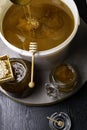 Honey in jar and big bucket, honeycomb and wooden stick, metal ladle Royalty Free Stock Photo