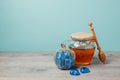 Honey jar and chocolate box on wooden table over mint wall. Jewish holiday Rosh Hashana background