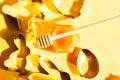 Honey jar, honey dipper and cookie cutters on yellow background Royalty Free Stock Photo