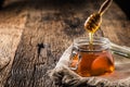 Honey jar with dipper on old woodn table Royalty Free Stock Photo