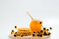 Honey jar. Dips wooden stick to glass bowl with liquid floral fresh honey