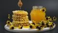 Honey jar. Dips wooden stick to glass bowl with liquid floral fresh honey