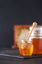 Honey jar, honeycomb and wooden spoon in jar on black background. Copy space. Autumn harvest concept Royalty Free Stock Photo